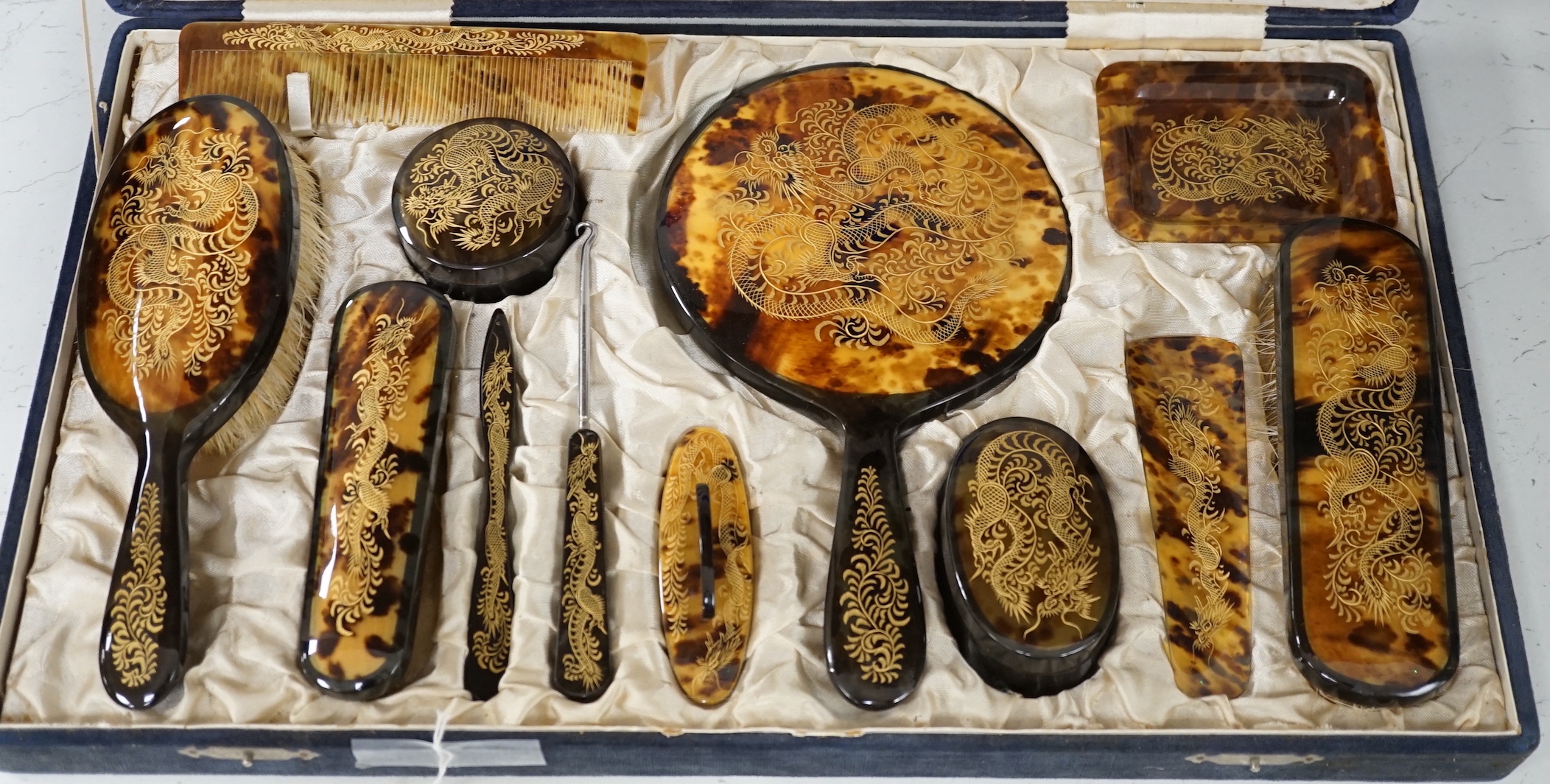 A cased Japanese tortoiseshell dragon decorated dressing table set, c.1940 (with original packing case sent from Hong Kong in 1940)